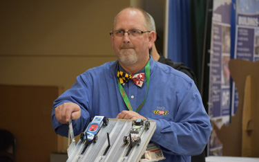 At MdQI, OPPE Assistant Division Chief Dennis Atkins checked out two competitors in the annual Pinewood Derby.